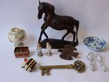 une figurine de cheval posée sur une table, à côté d'autres objets