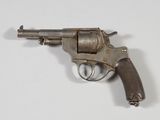 un vieux pistolet avec une poignée en bois sur une surface blanche