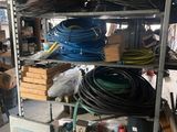 many different types of hoses on the shelves in the garage