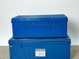 two blue storage boxes sitting on top of a carpeted floor
