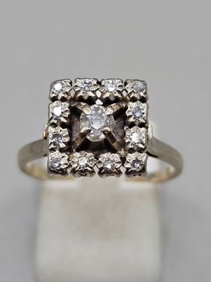 a close up of a diamond ring on a white surface