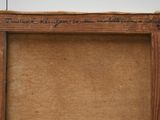 an old picture frame with writing on it sitting on a table