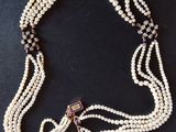 a close up of a necklace on a table with a black background