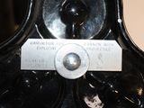 a black vase with a label on it sitting on a table