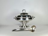 une assiette en argent sur laquelle repose une cuillère