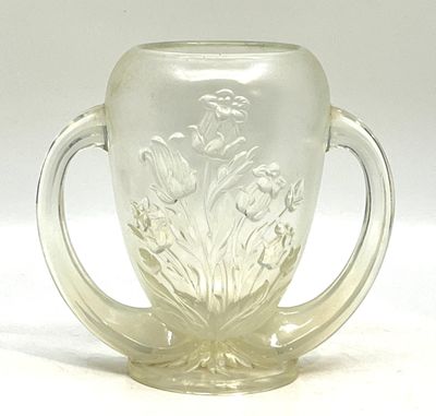 un verre muni d'une anse et orné d'un motif floral
