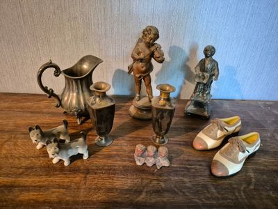de nombreuses figurines posées sur une table, avec des chaussures et un vase
