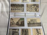 a box of old photographs on a bed with sheets of paper