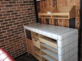 une cuisine avec un mur en briques et un plan de travail en carrelage blanc