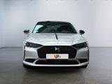 the front view of a silver car parked in a white room