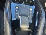 the interior of a car with a steering control and a phone in the center of it