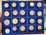 someone is holding a blue box with a lot of coins in it