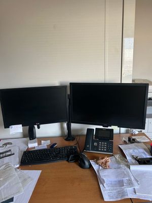 un bureau équipé de deux écrans d'ordinateur et d'un clavier