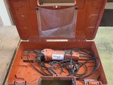 une boîte à outils orange contenant des outils, posée sur une table