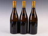three bottles of wine sitting next to each other on a white surface