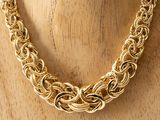 a close up of a gold chain necklace on a mannequin mannequin
