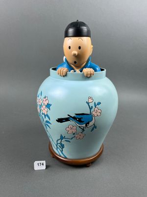 une figurine représentant un homme assis dans un vase bleu