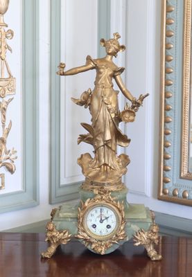 une horloge dorée posée sur une table en bois dans une pièce