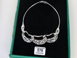 un bracelet en argent qui a été placé dans une boîte verte