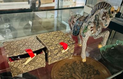 a glass display case with a horse and a box on it