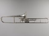 an old silver trumpet is hanging from the ceiling in a room