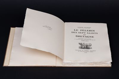 un livre ouvert posé sur une table noire, devant un fond noir