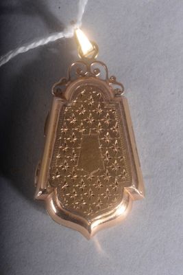 une médaille d'or suspendue à un fil sur une surface blanche