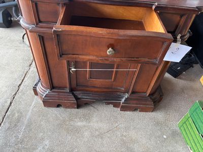 a wooden cabinet with a drawer on top of it