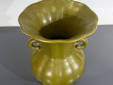 un vase vert posé sur une table