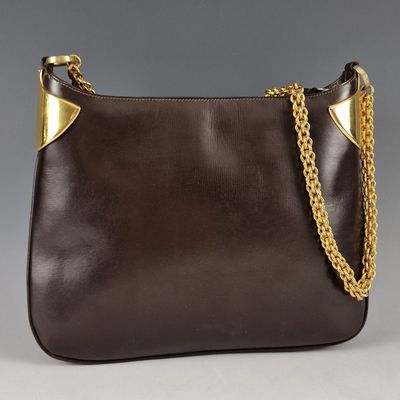 a brown purse with a gold chain hanging from it