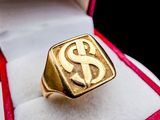 an image of a gold ring with a dollar sign on it in a box