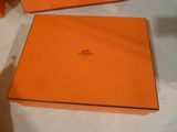 Deux boîtes orange sont posées sur une table recouverte d'une nappe blanche