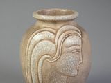 a vase with a face on it sitting on a table