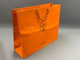 un sac de courses orange avec un logo dessus