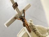 a statue of a person holding a cross on top of a building