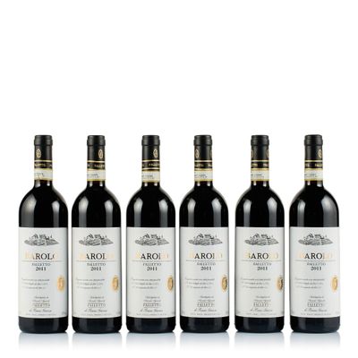 quatre bouteilles de vin sont alignées sur une surface blanche