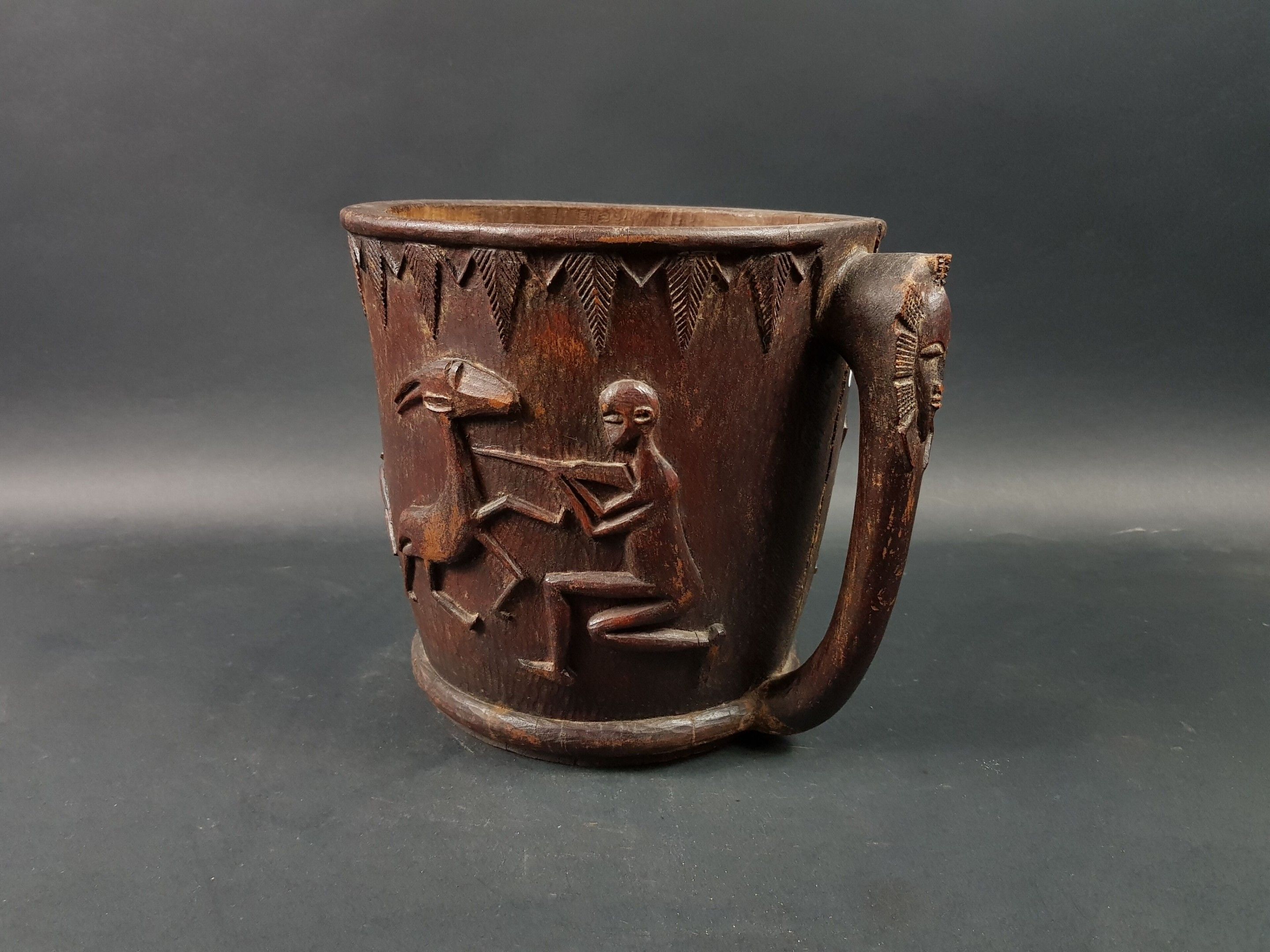 Mortier Senoufo, Côte d'Ivoire Bois sculpté d'une frise à décor de scènes de chasse et de guerre, anse à décor de mas...