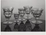 photographie en noir et blanc représentant plusieurs verres à vin posés sur une table