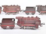 quatre petits trains miniatures posés sur une surface blanche
