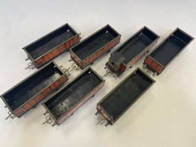 six wagons de train miniature alignés les uns à côté des autres sur une surface blanche