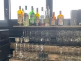 many glasses and bottles on a shelf in a room
