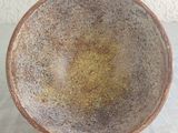 a brown bowl sitting on a table with a white table cloth