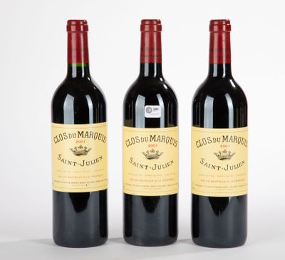trois bouteilles de vin rouge posées l'une à côté de l'autre sur une surface blanche