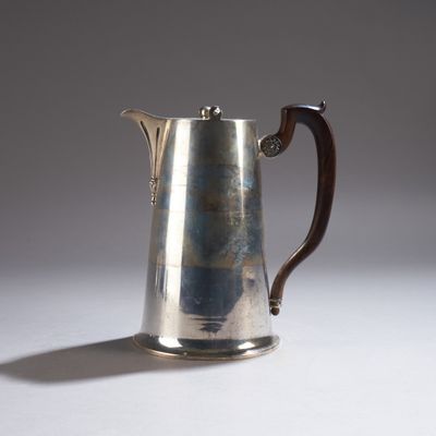 une cafetière en argent avec un manche en bois sur une table