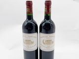 deux bouteilles de vin rouge posées l'une à côté de l'autre sur une surface blanche