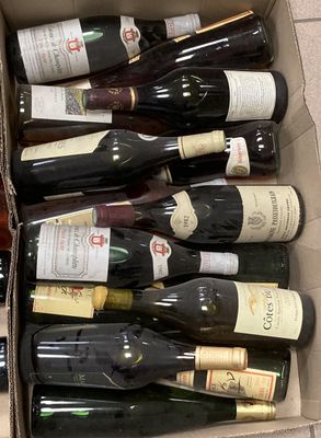 Les bouteilles de vin se trouvent dans un carton posé sur un sol carrelé.