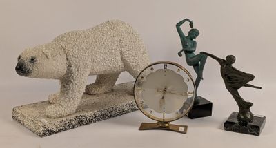 une statue d'ours polaire à côté d'une horloge et d'une statue de femme