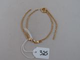 bracelet plaqué or avec une étiquette de prix sur fond blanc