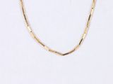 a close up of a gold necklace on a white background