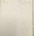 an old book with writing on it sitting on top of a table